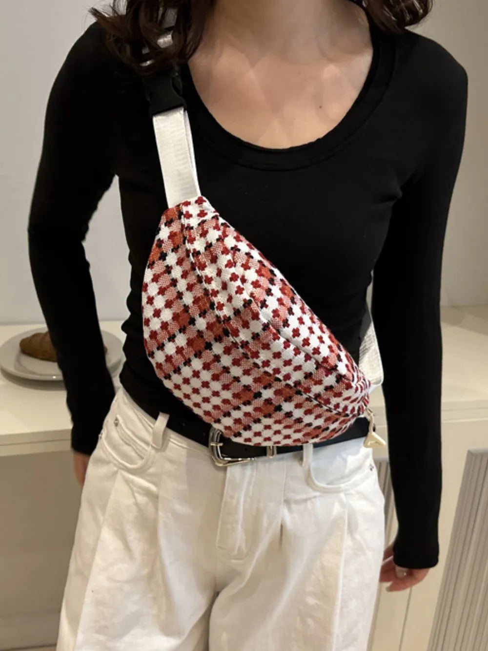 Crossbody-/Umhängetasche mit breitem kariertem Schulterriemen.