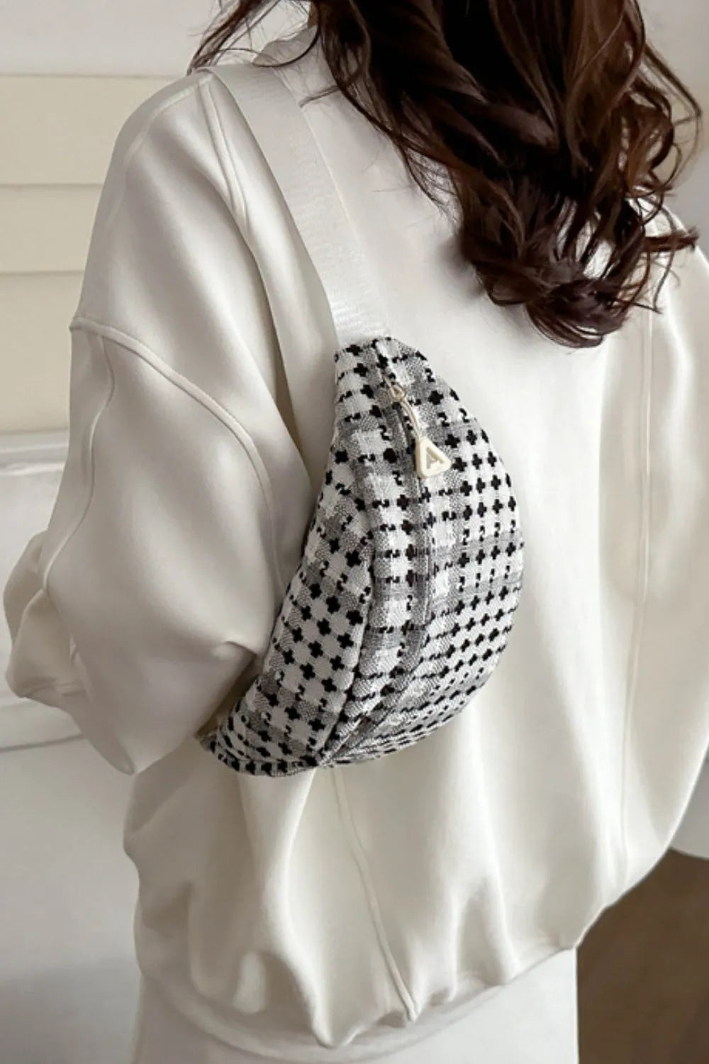 Crossbody-/Umhängetasche mit breitem kariertem Schulterriemen.